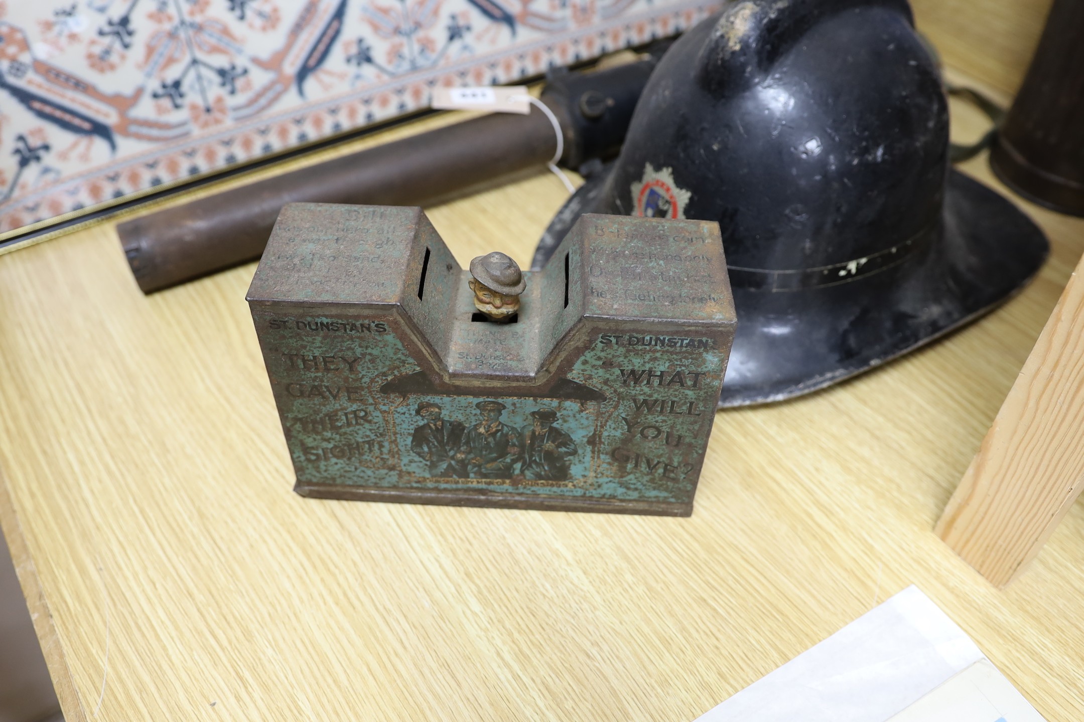 A WW2 gas mask in original metal case, together with other related ephemera, including an enamelled sign, a fire brigade hat, etc.